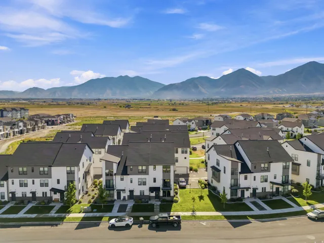 Aerial view of a residential community featuring contemporary townhomes with dark roofs and light-colored siding