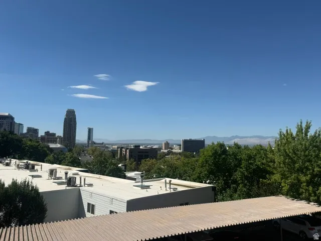 Skyline panorama featuring prominent downtown architecture and distant mountain ranges
