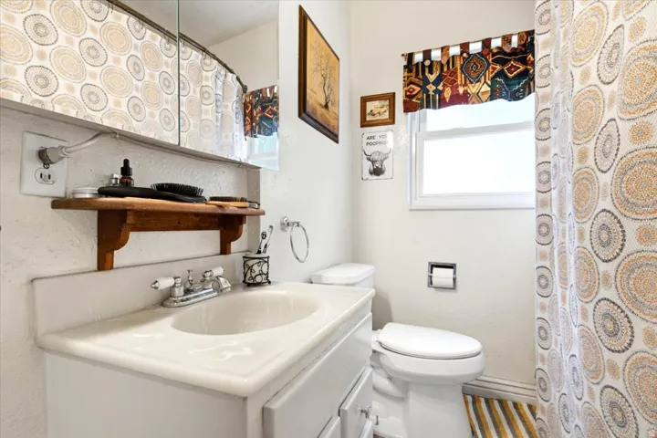 Bathroom featuring a white vanity with integrated sink, chrome-finish faucet, and overhead mirrored medicine cabinet