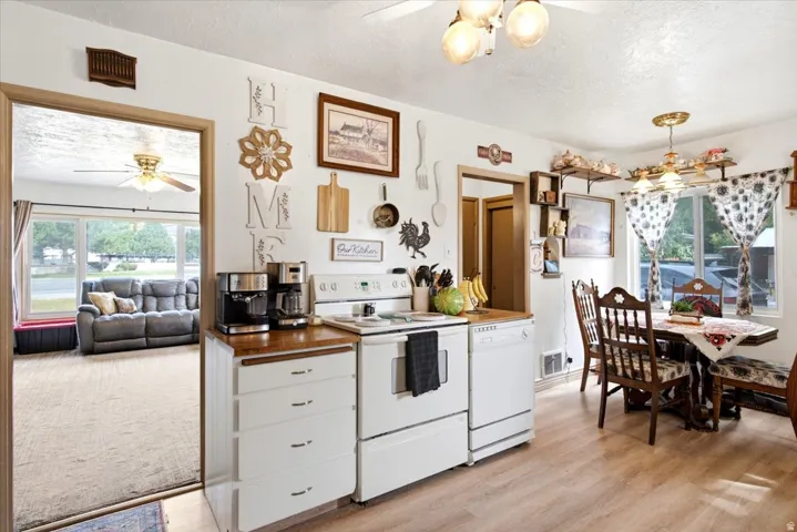 Kitchen featuring wood-finish flooring, white appliances, and a wood countertop
