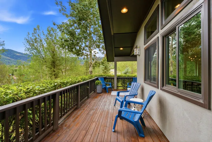 Expansive outdoor deck featuring wood-finish flooring, a sturdy railing, and an overhead awning