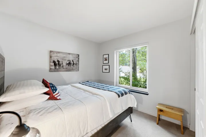 Bright interior space featuring a window with a lake and tree backdrop