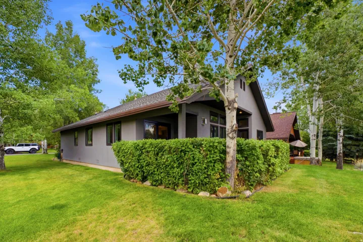 Gray stucco exterior with a dark shingle roof