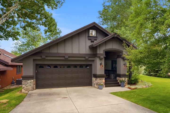 Craftsman-style exterior featuring a prominent two-car garage with arched window inserts