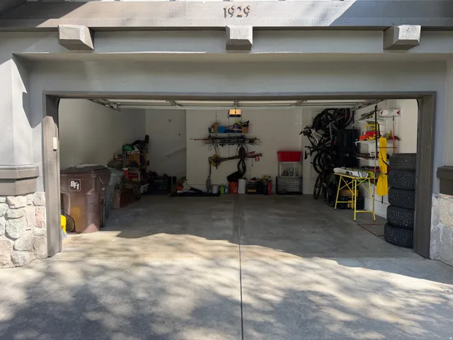 Integrated two-car garage featuring a concrete floor and white interior walls