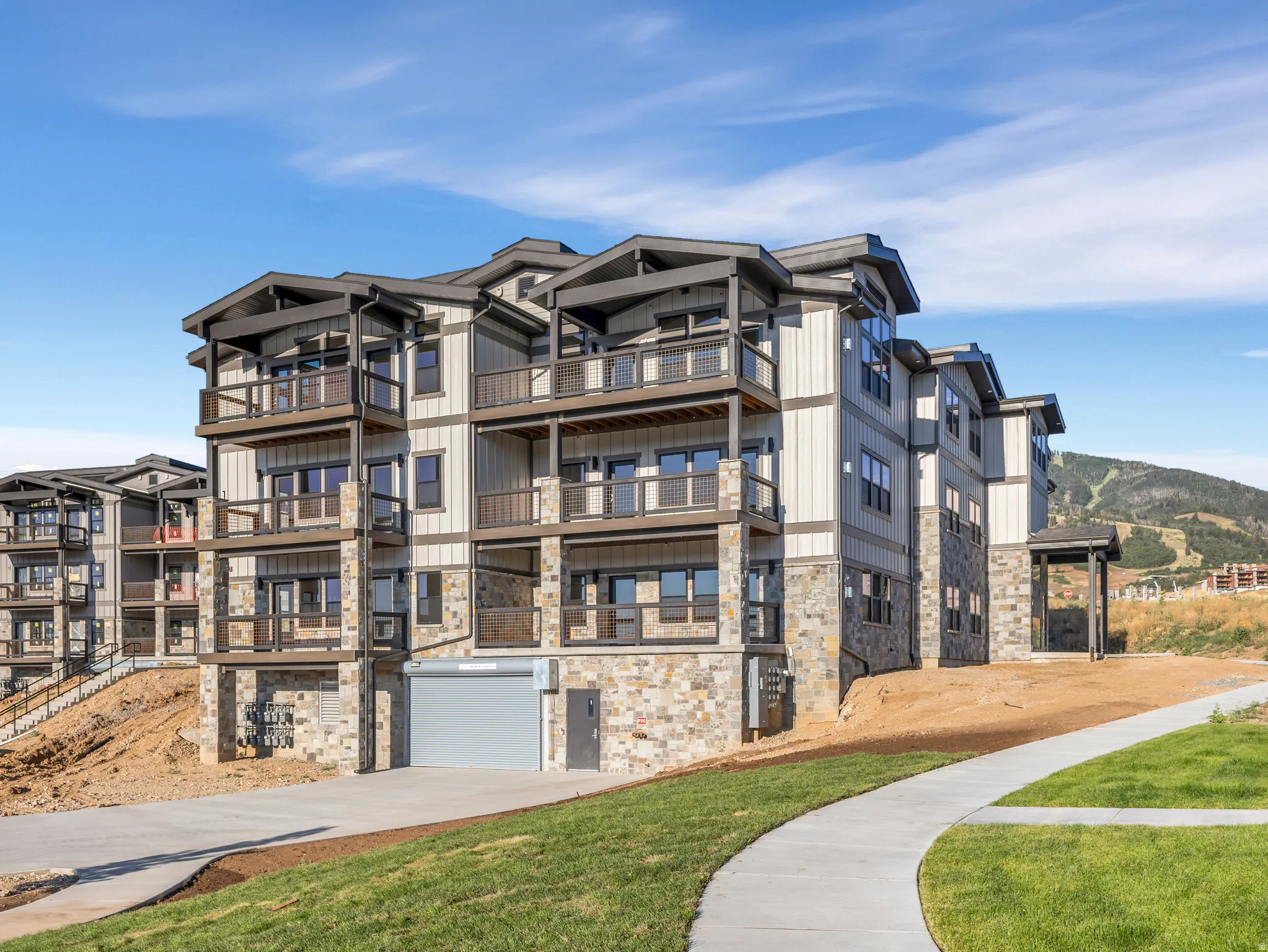 Multi-story residential building featuring stone and siding exterior finishes