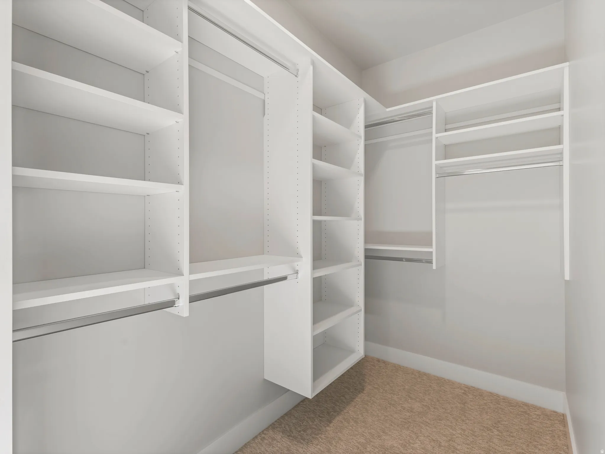 Custom closet system featuring white shelving units, multiple hanging rods, and adjustable shelves