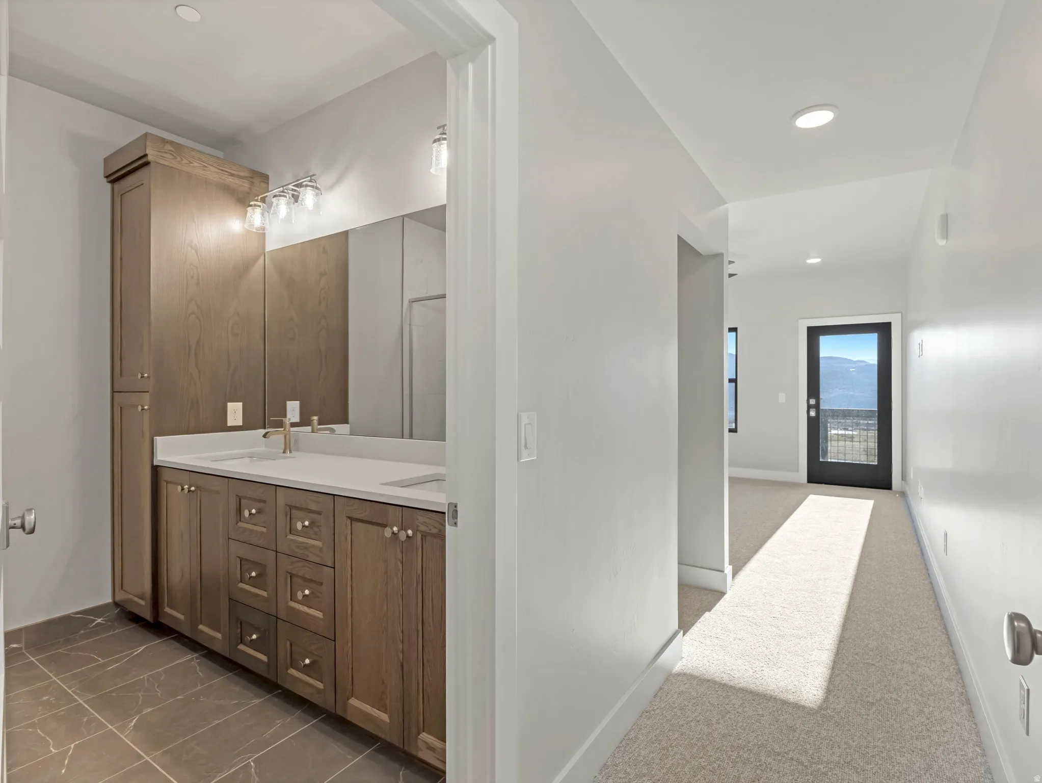 Double vanity with white countertops, undermount sinks, and gold-finish faucets