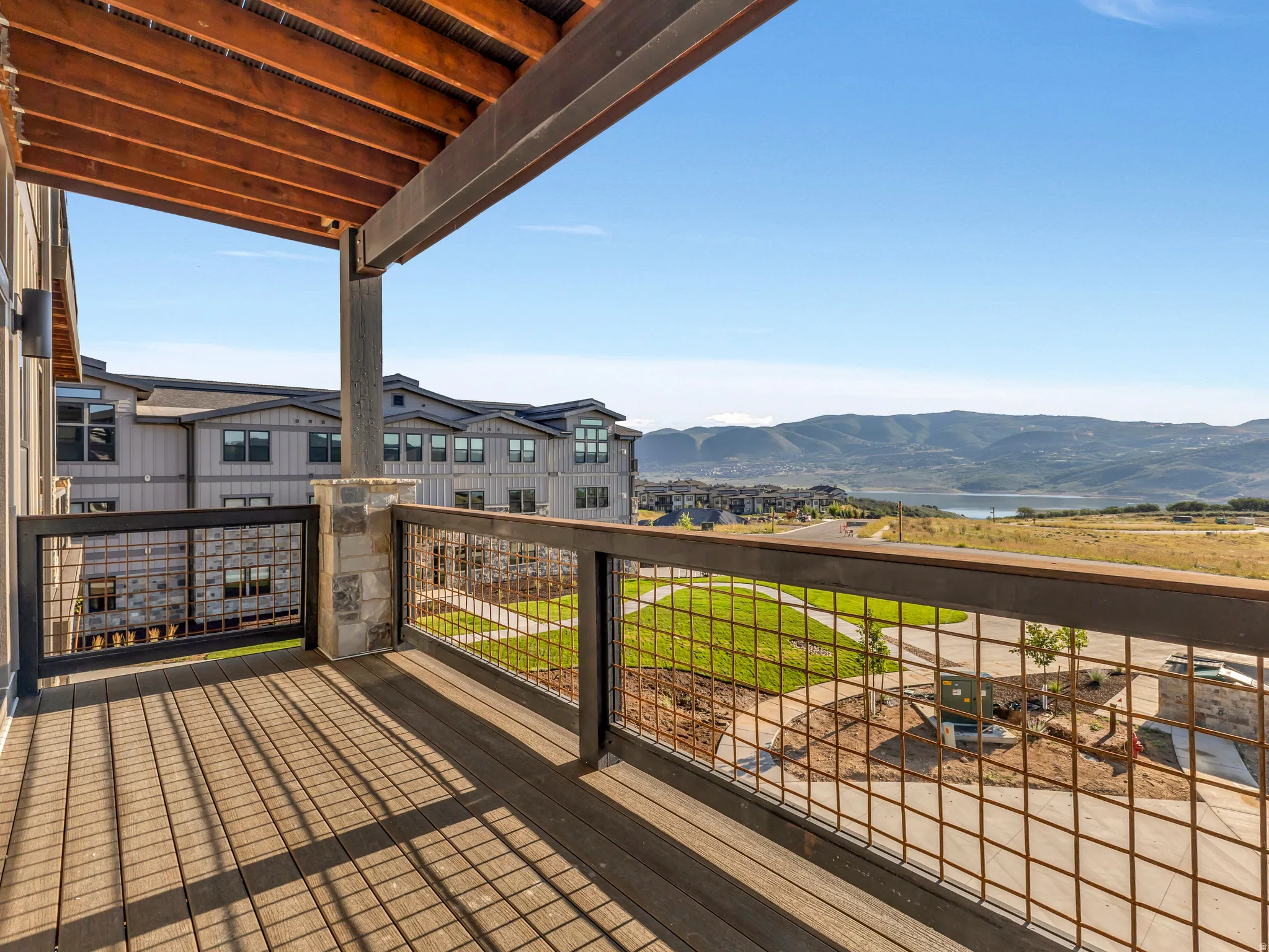 Private balcony featuring wood-finish decking and metal grid railing