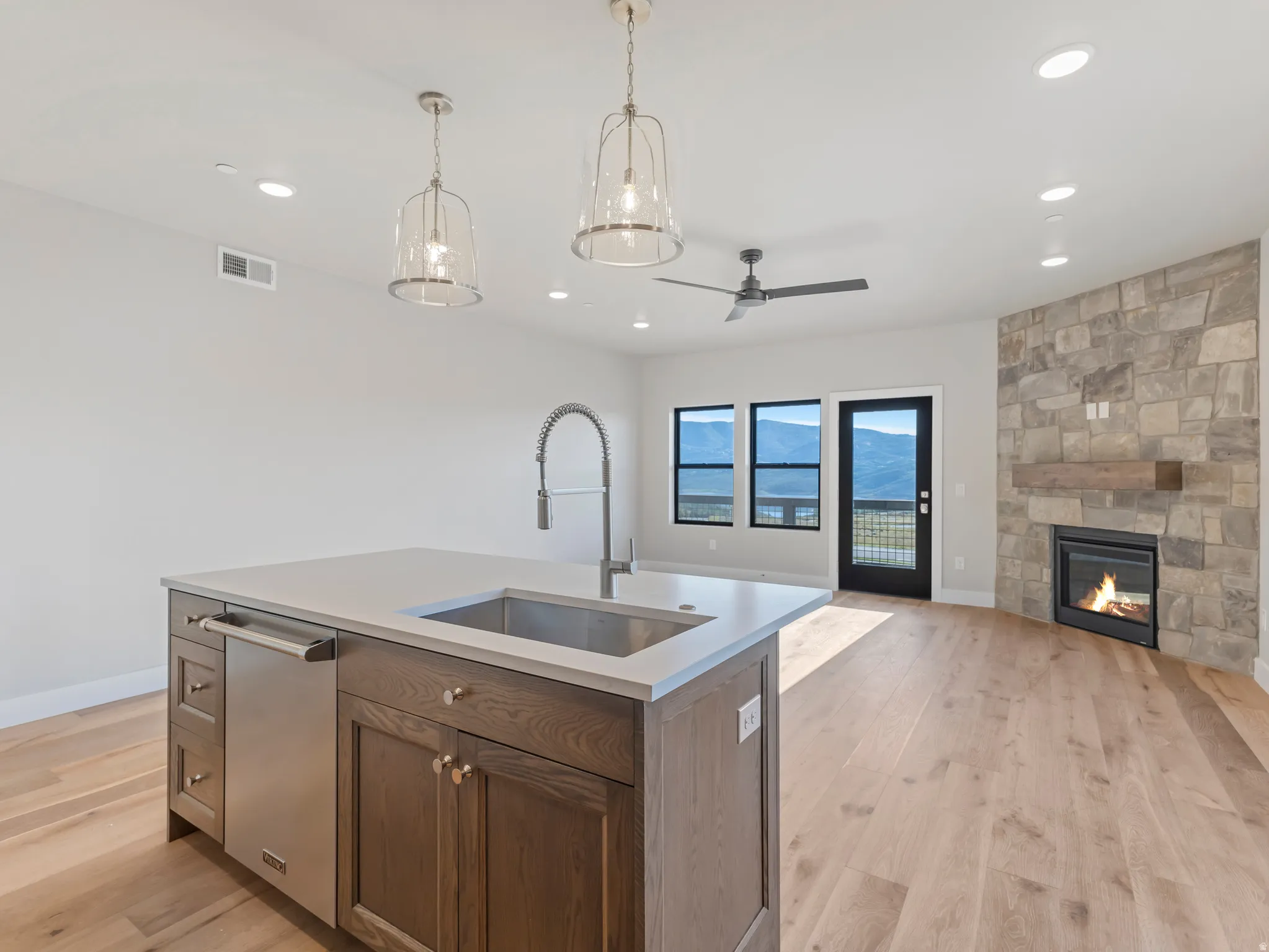 Kitchen island with a built-in stainless steel dishwasher, undermount sink, and gooseneck faucet