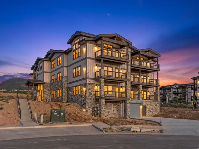 Multi-story building featuring stacked stone and vertical siding