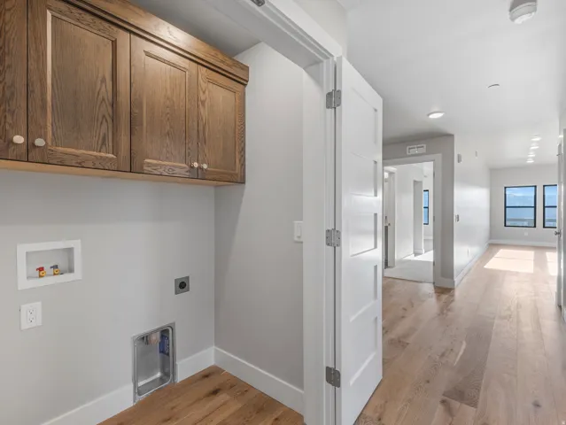 Dedicated laundry space featuring wood cabinetry and white trim