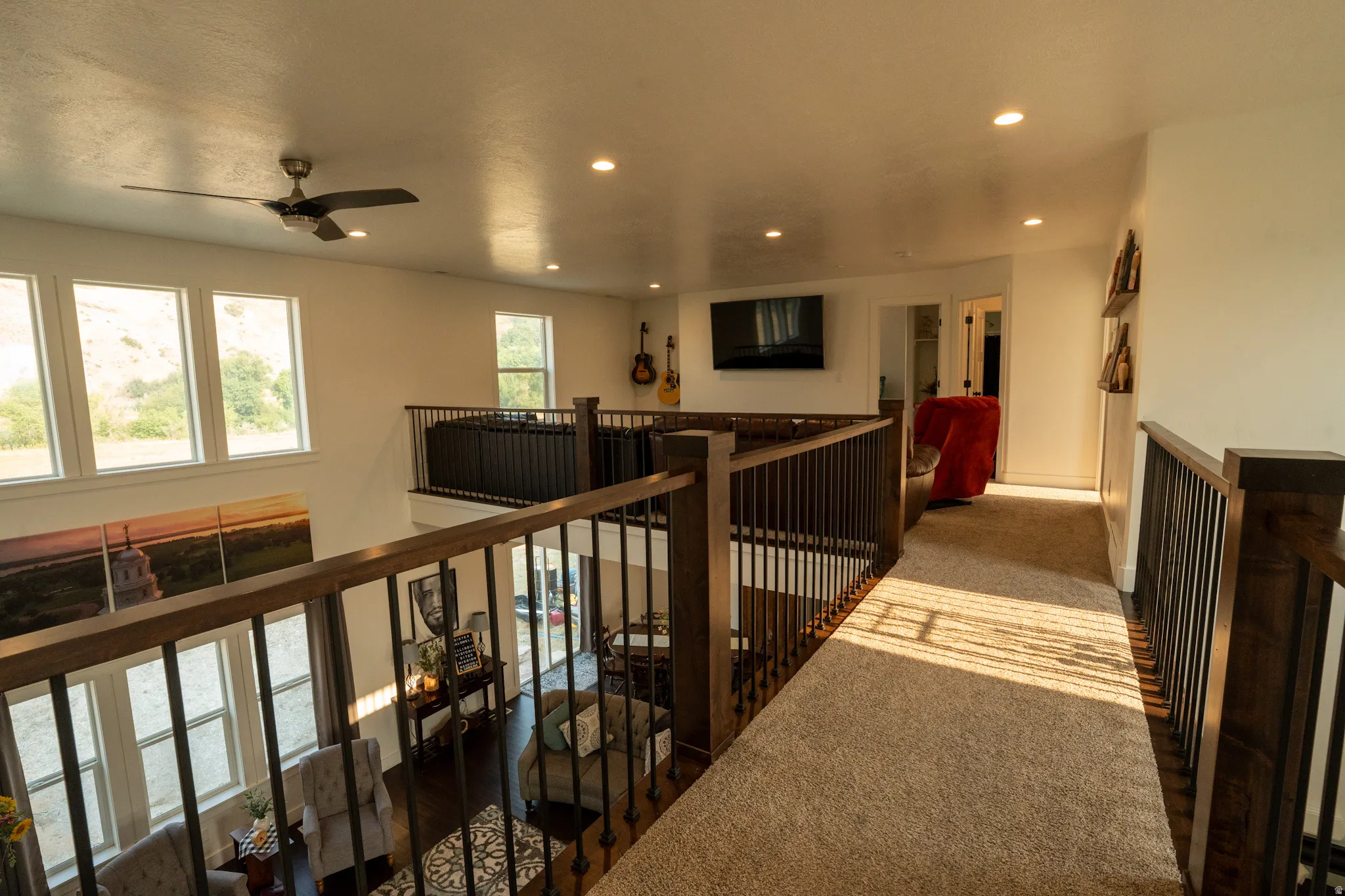 Carpeted upper-level landing featuring a wood and metal railing system