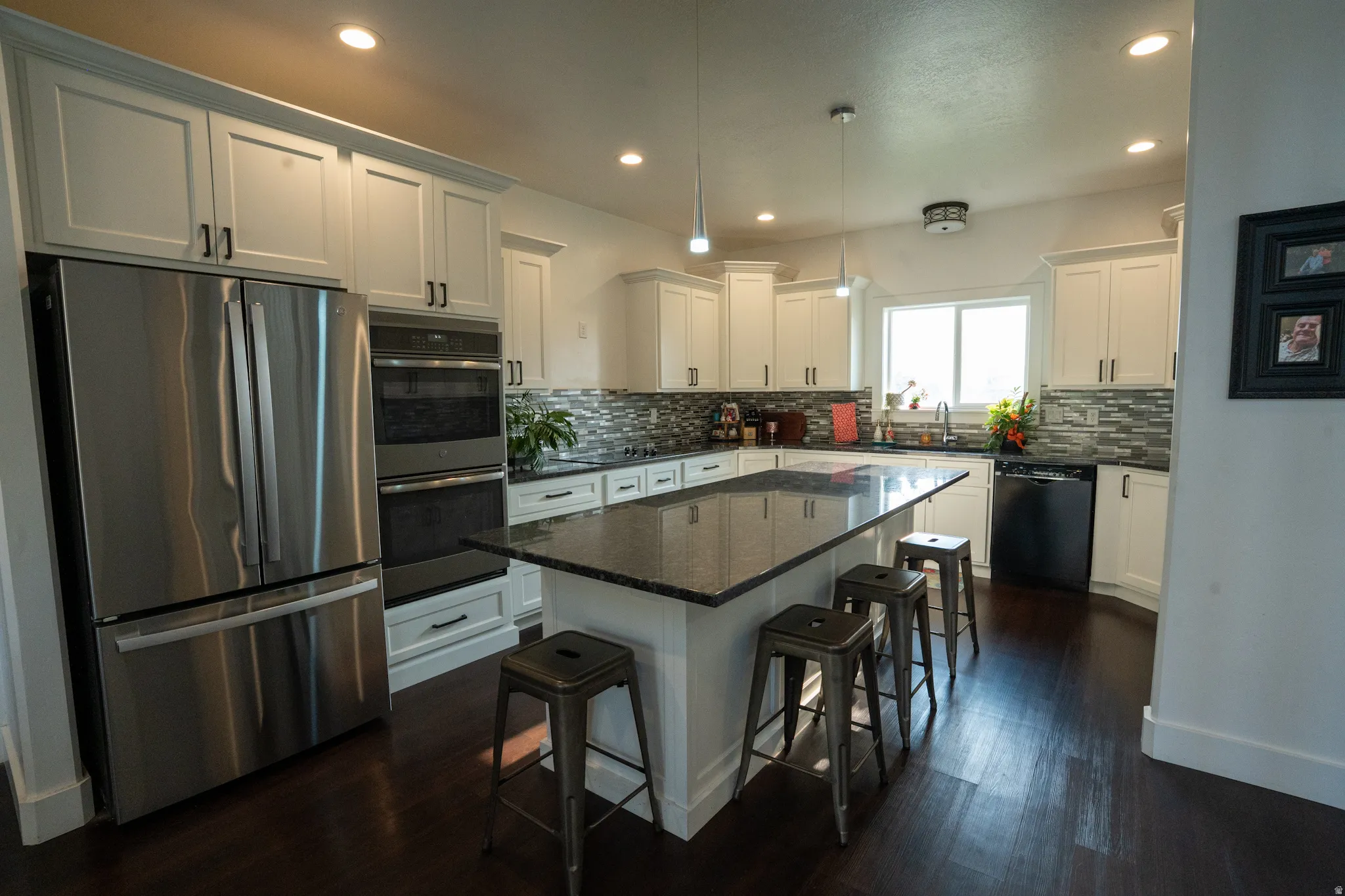 Contemporary kitchen featuring custom white cabinetry, stainless steel French-door refrigerator, and dual wall ovens
