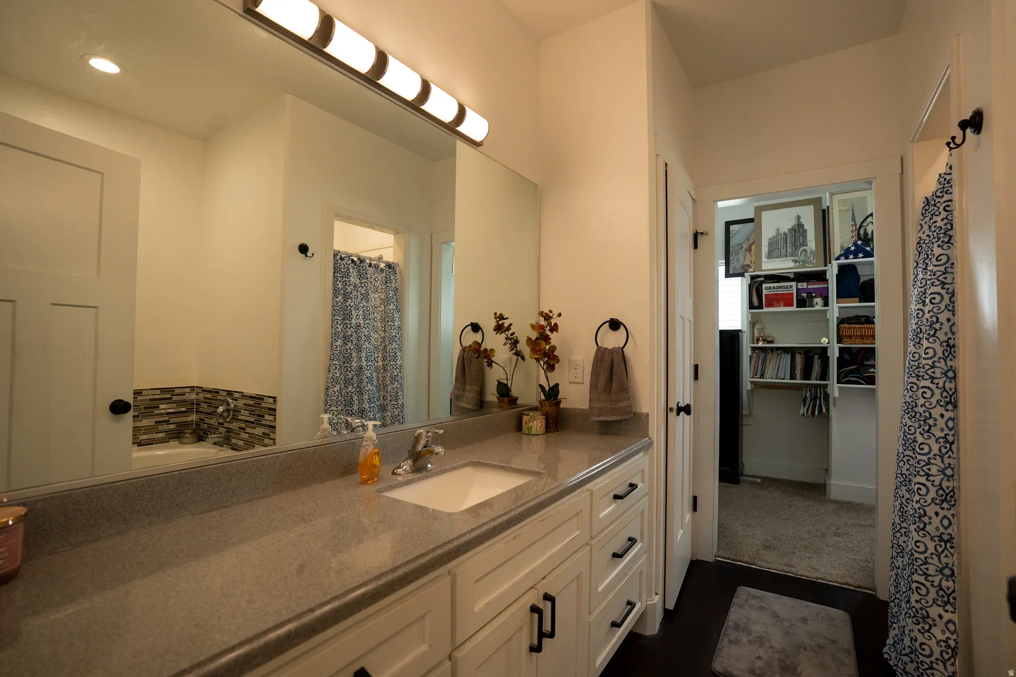 Spa-inspired primary bathroom featuring a spacious dual-sink vanity with ample storage, quartz countertop, and contemporary hardware