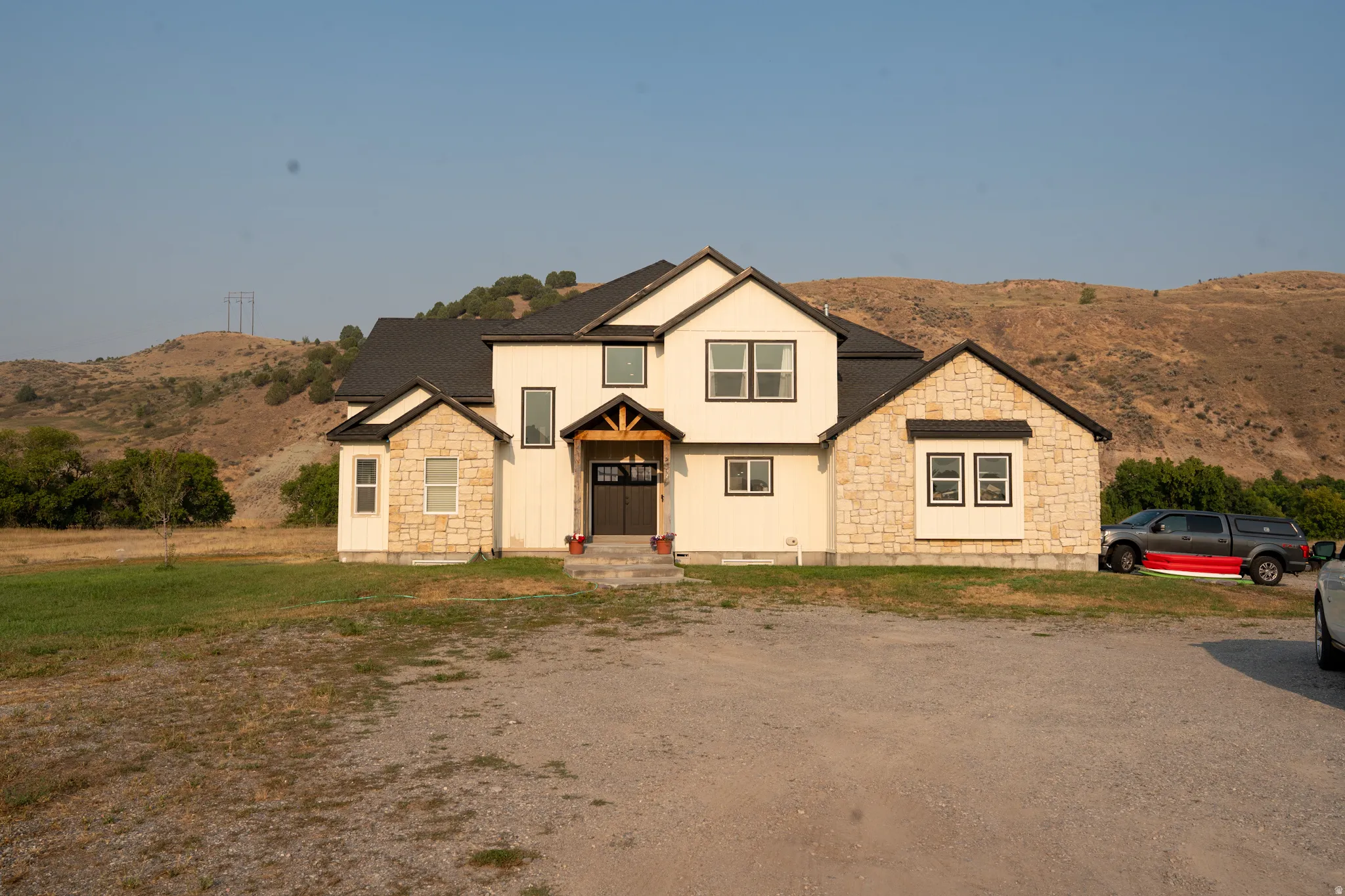 Contemporary residence featuring a light-colored board and batten facade with natural stone accents