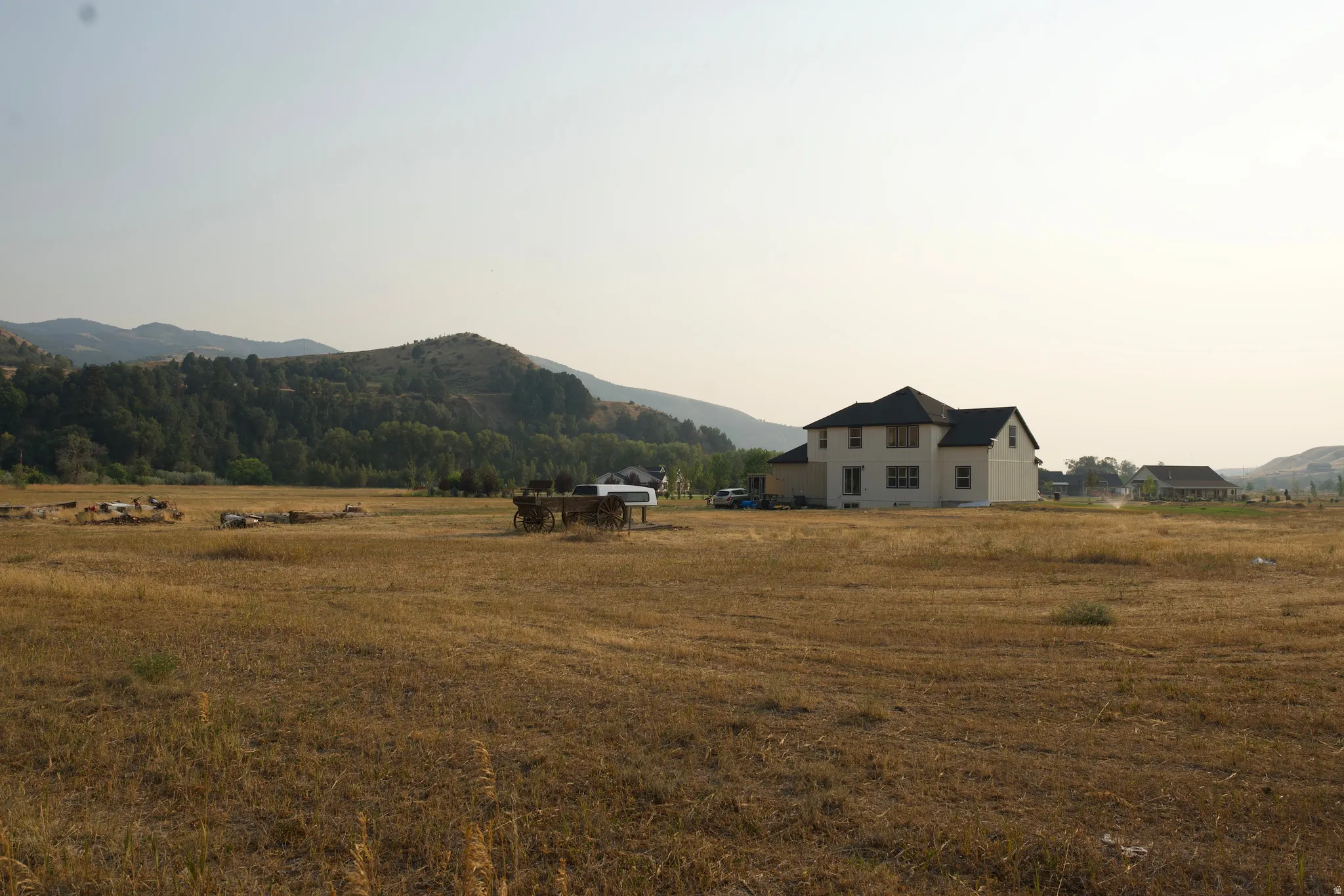 Expansive rural property featuring a two-story residence with a light-colored exterior and pitched roof set on substantial acreage