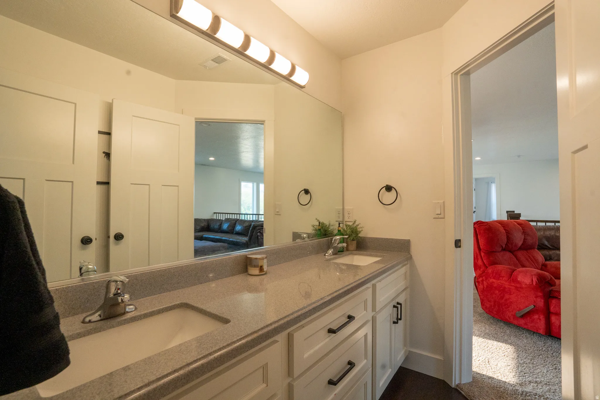 Spa-inspired primary bathroom featuring dual vanity with ample storage, quartz countertop, and chrome fixtures