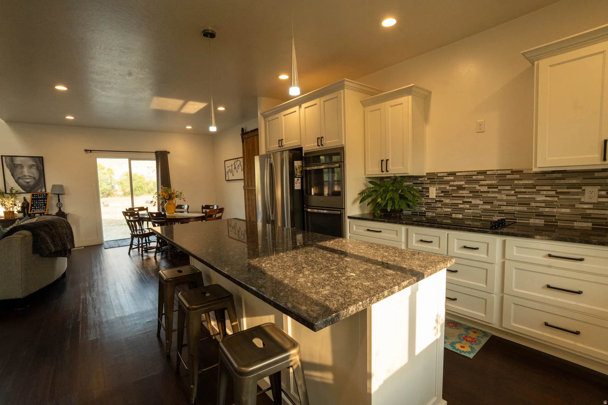 Gourmet kitchen featuring cream-colored cabinetry with hardware accents, granite countertops, and a large center island with seating