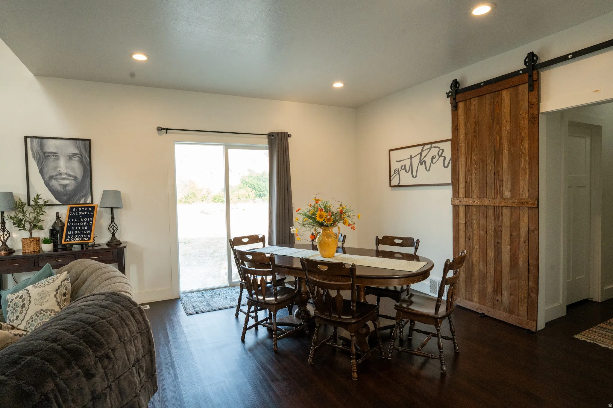 Dining area featuring dark wood-finish flooring, recessed lighting, and a sliding glass door