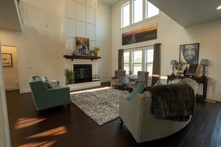 Soaring two-story great room with floor-to-ceiling windows flooding the space with natural light