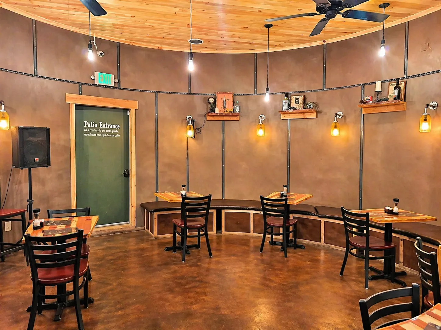 Curved interior space featuring a wood-panel ceiling, concrete flooring, and built-in bench seating