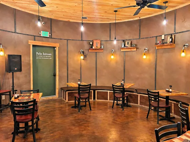 Curved interior space featuring a wood-panel ceiling, concrete flooring, and built-in bench seating