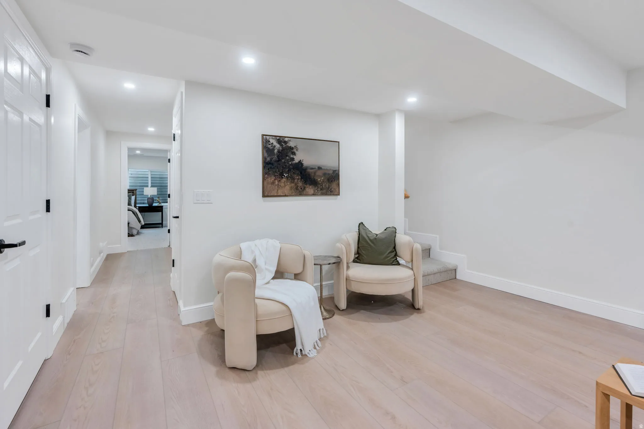 Neutral-toned living space featuring light wood-finish flooring and recessed lighting