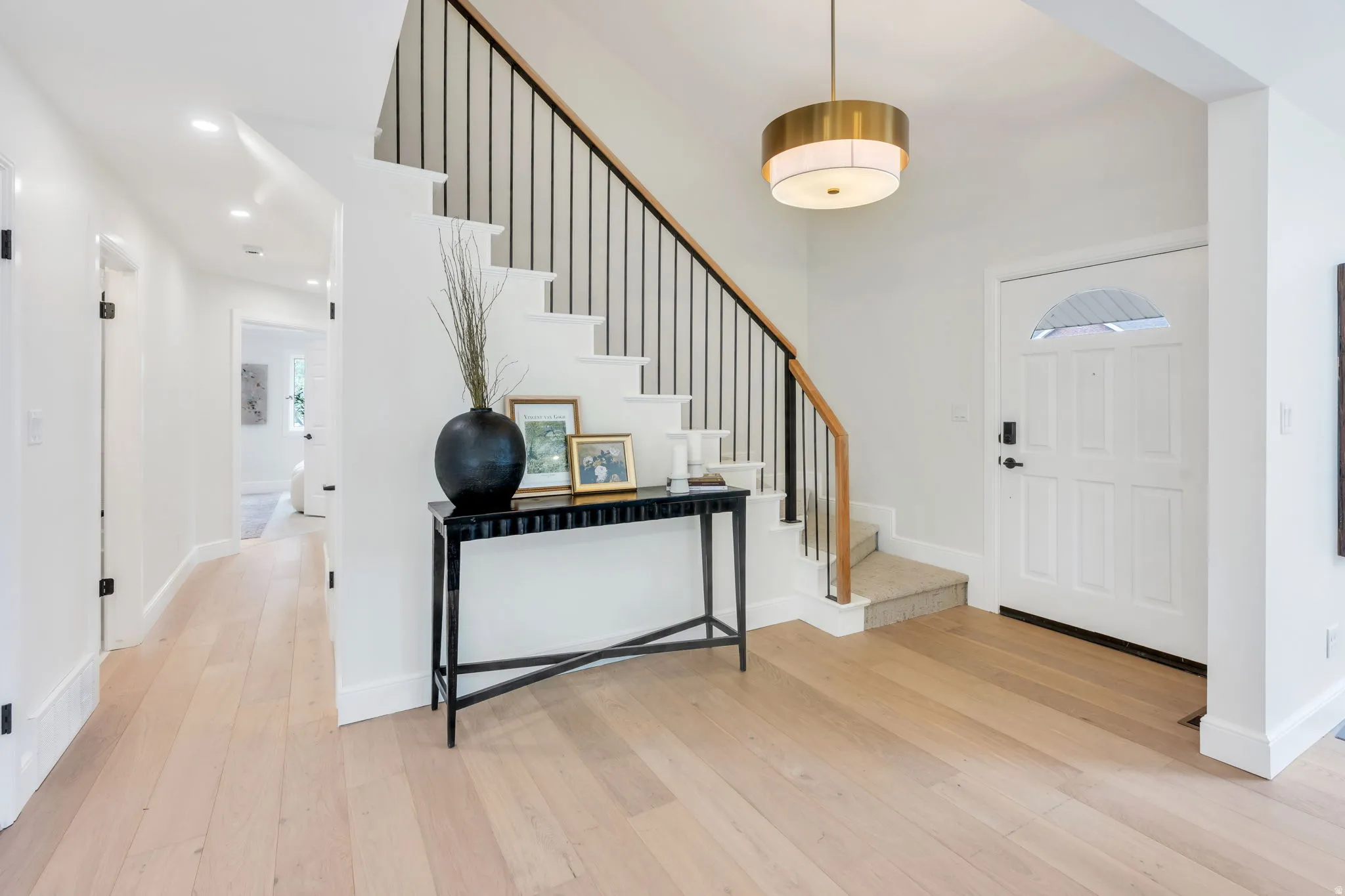 Entryway featuring light wood-finish flooring and a white paneled door with an arched glass insert