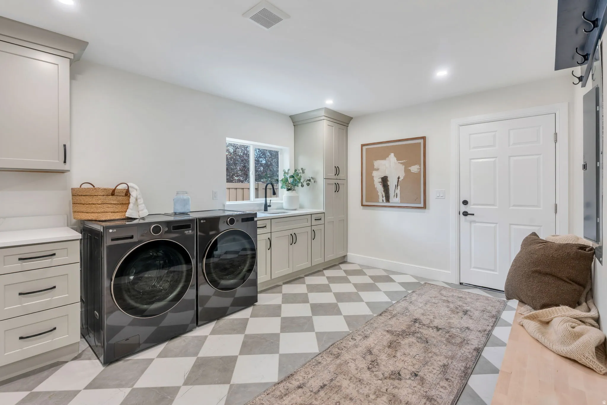 Utility room featuring checkerboard tile flooring, built-in cabinetry with white countertops, a sink with a matte black faucet, and recessed lighting