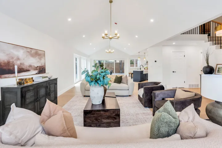 Vaulted ceilings with recessed lighting, light wood-finish flooring, and a contemporary chandelier