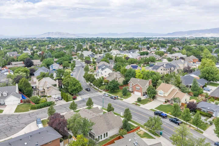 Expansive residential area featuring a diverse collection of homes, mature tree-lined streets, and distant mountain ranges