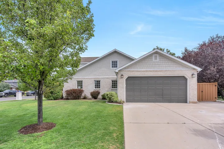 Stucco and shingle-sided residence with a two-car garage and concrete driveway