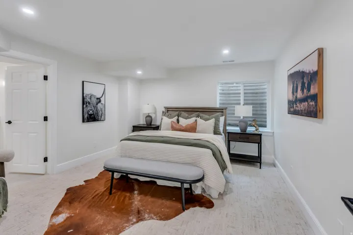 Light-filled room featuring a paneled interior door with matte black hardware, recessed lighting, and a window with blinds