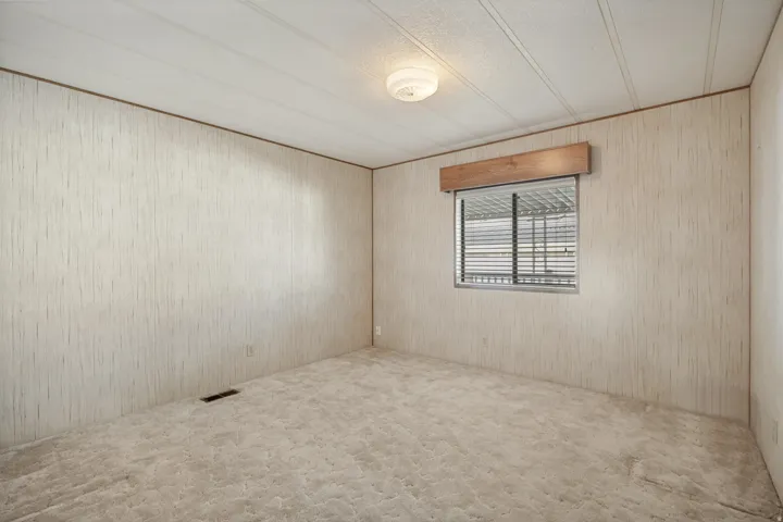 Room featuring a window with horizontal blinds and a wood valance
