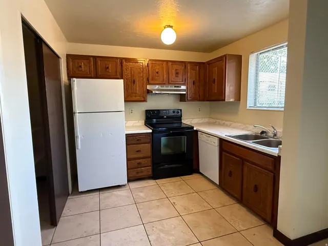 Kitchen featuring wood cabinetry, light-toned countertops, and tile flooring