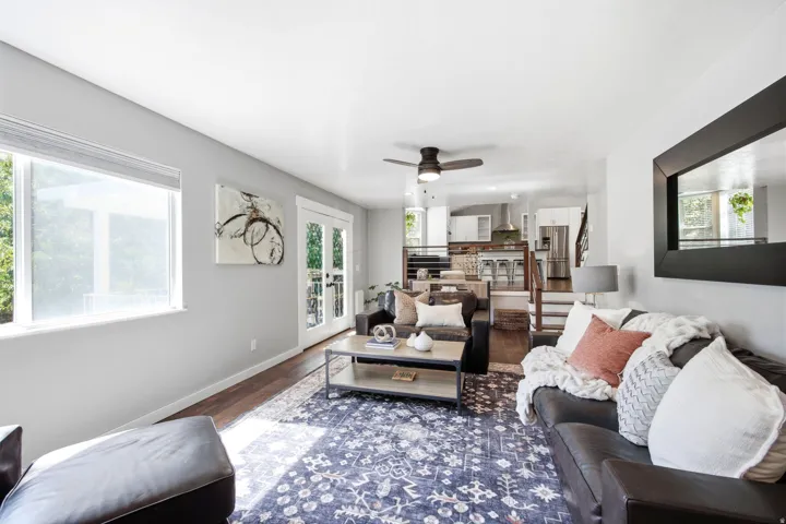 Open concept living area featuring dark wood-finish flooring, a contemporary ceiling fan, and light-toned wall paint
