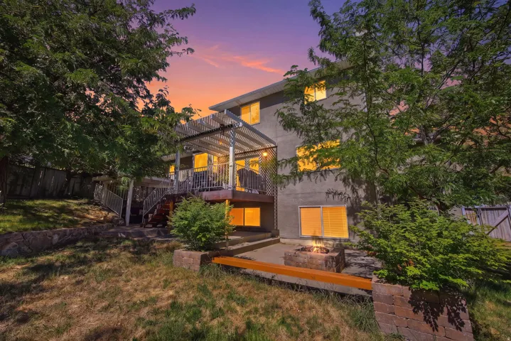 Rear exterior featuring a multi-level deck with a white pergola