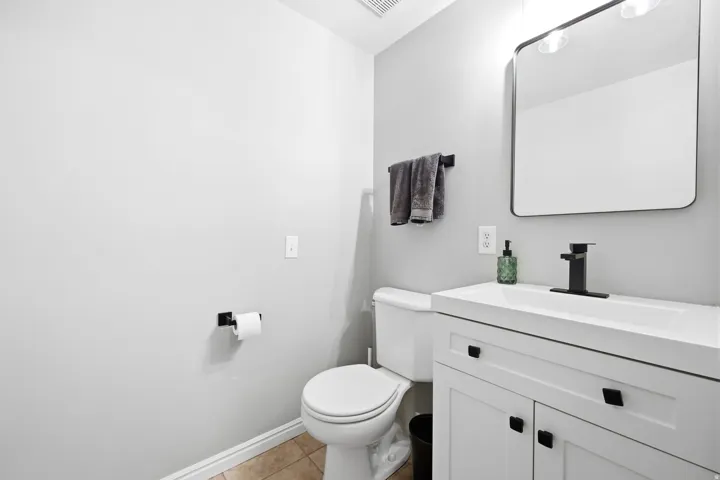 Bathroom featuring a white vanity with black hardware, integrated sink, and black single-handle faucet