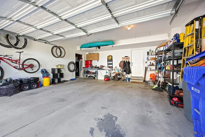 Spacious garage with textured concrete flooring, white paneled walls, and an overhead lighting fixture
