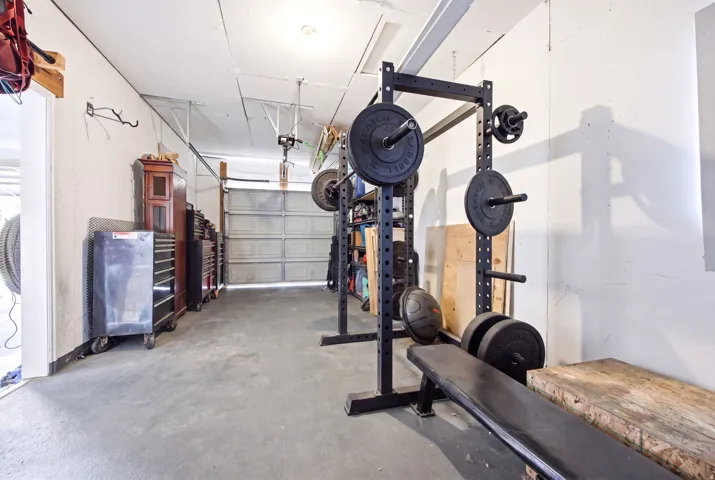 Spacious garage featuring a concrete floor, overhead lighting, and a roll-up garage door