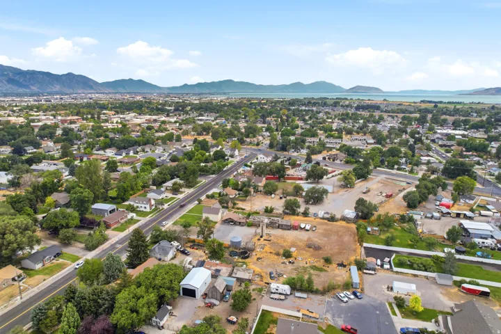 Expansive aerial view showcasing a residential area with extensive tree coverage and mountain ranges in the distance