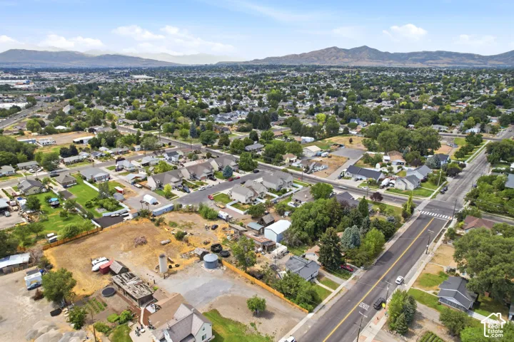 Expansive aerial view showcasing a developed residential area with numerous single-family homes, mature trees, and paved streets