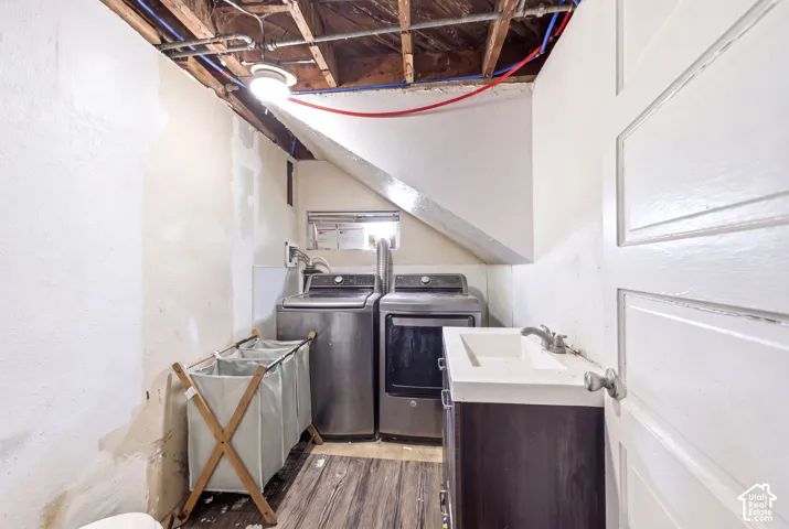 Laundry area featuring wood-finish flooring and a built-in vanity with an integrated sink