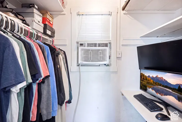 Compact room featuring a window-mounted air conditioning unit