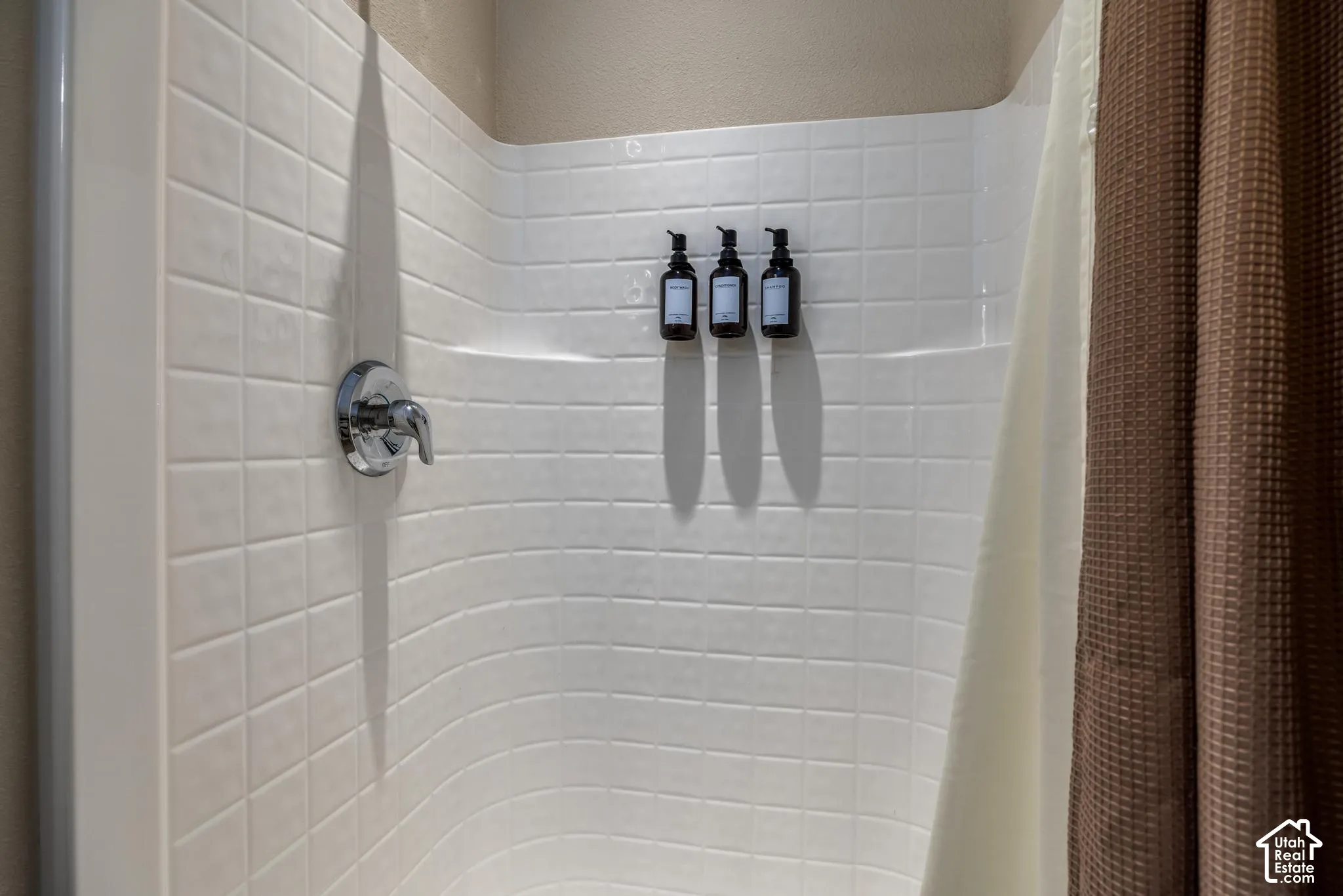 White subway tile shower surround with chrome fixtures