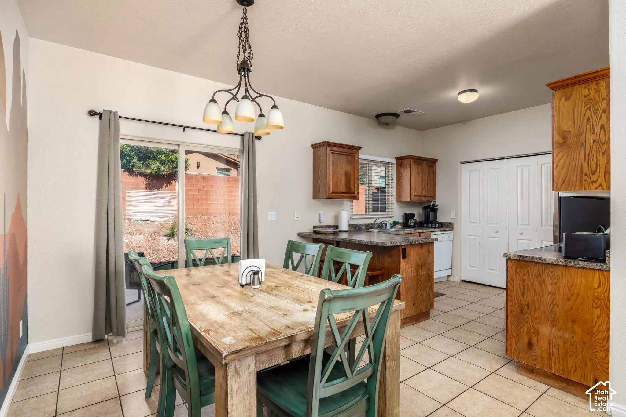 Open-concept kitchen and dining area featuring tile flooring, wooden cabinetry, and countertops
