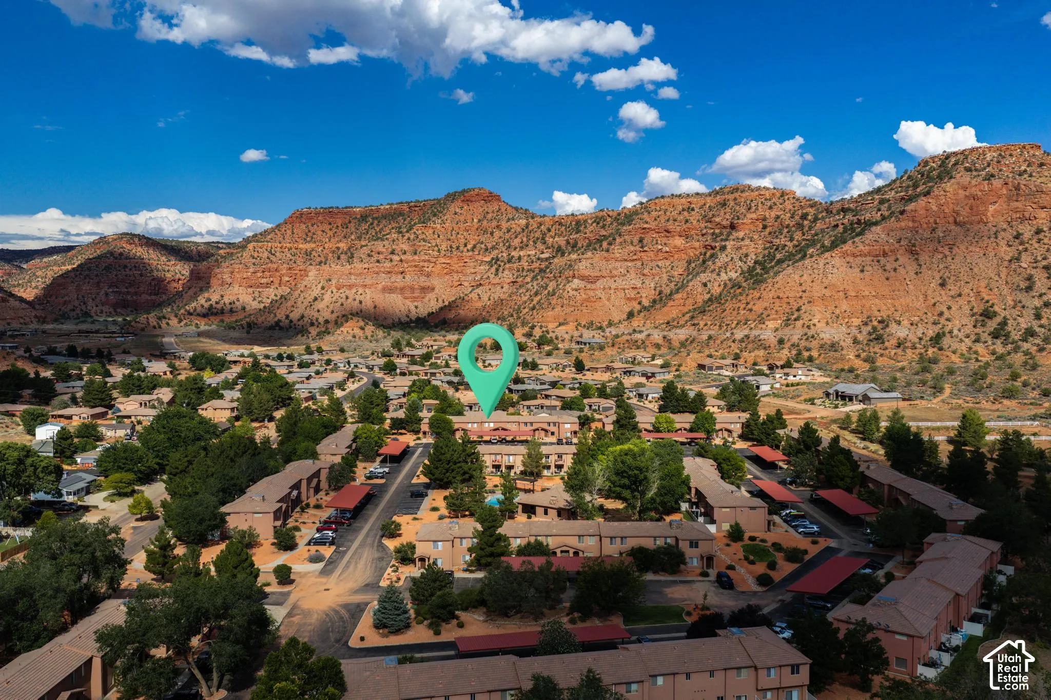 Aerial perspective showcasing a residential community with red rock formations in the background