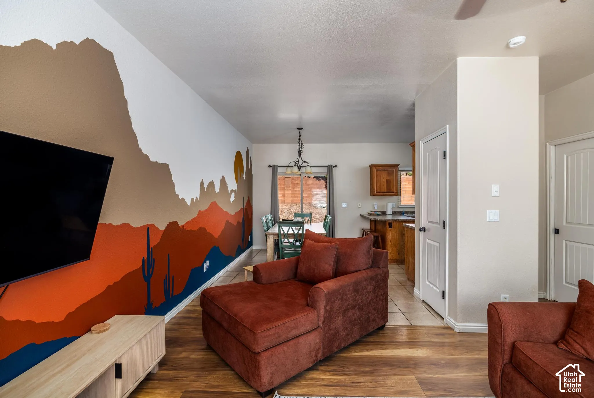 Open-concept living area featuring wood-finish flooring, a decorative wall mural, and recessed lighting