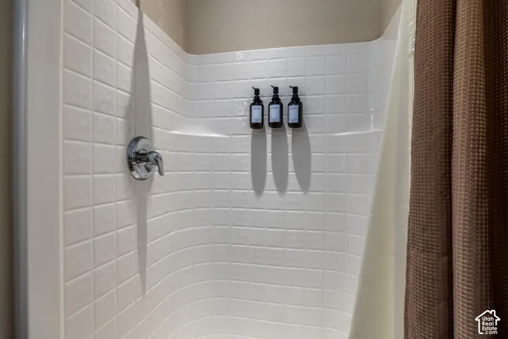 White subway tile shower surround with chrome fixtures